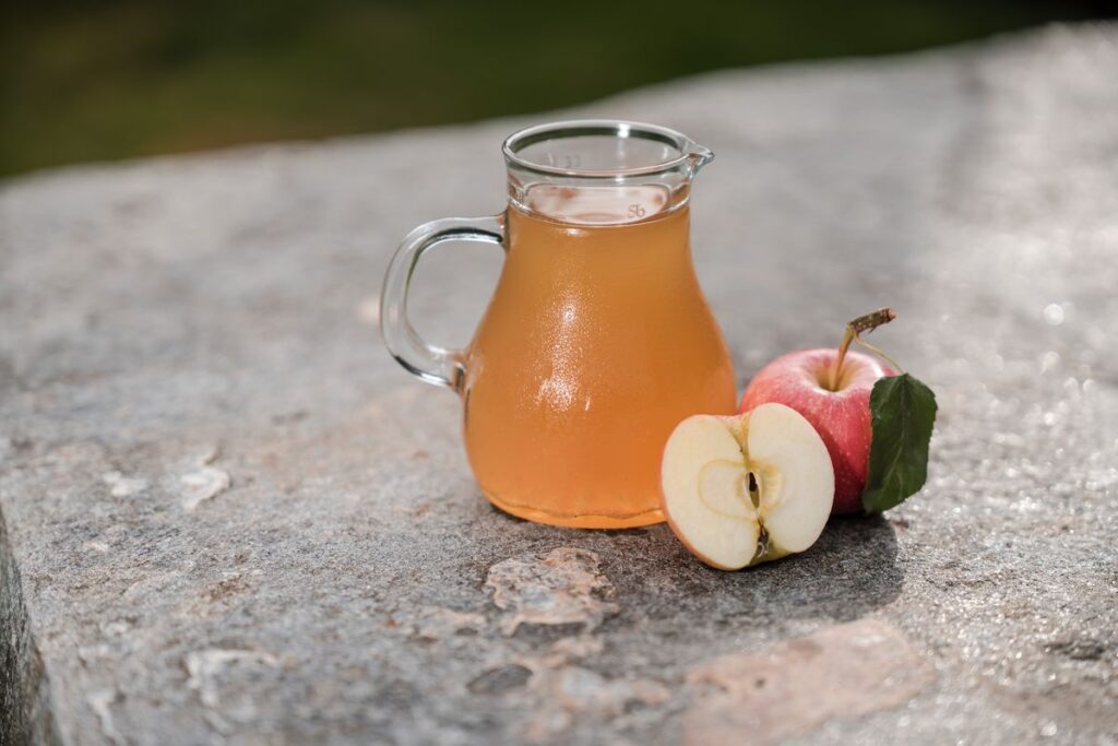 Succo di mela nella caraffa di vetro con mele fresche