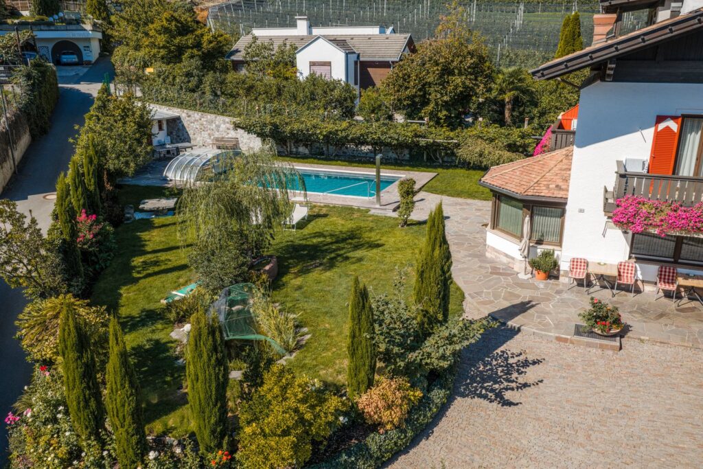 La Pension Mitterhofer con giardino, piscina e parcheggio coperto vista dall’alto